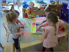 children playing around table in nursery