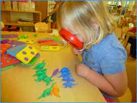image of little girl with magnifying glass exploring.